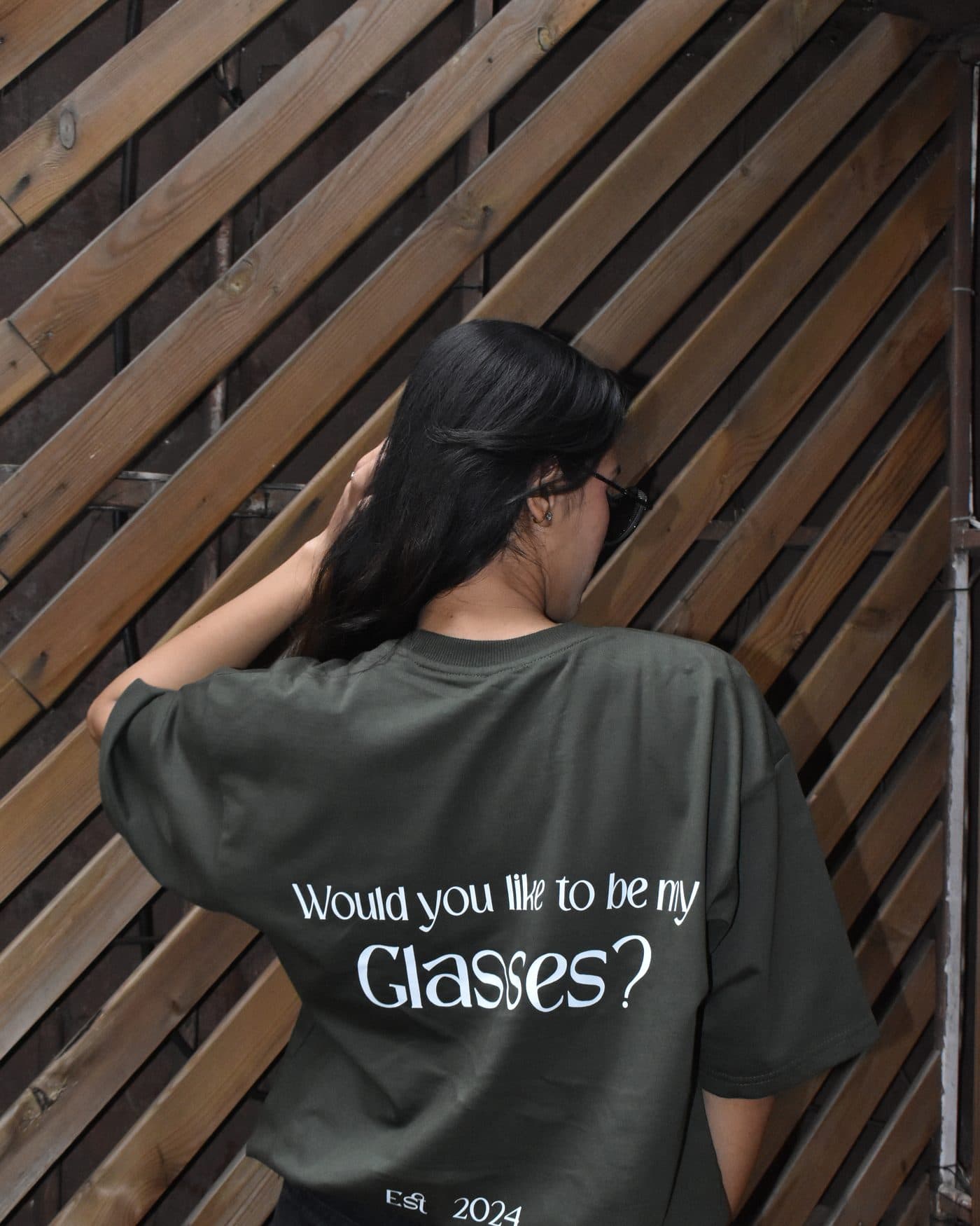 Back of the DEUS Glasses olive green oversized T-shirt showing the “Would you like to be my Glasses?” print